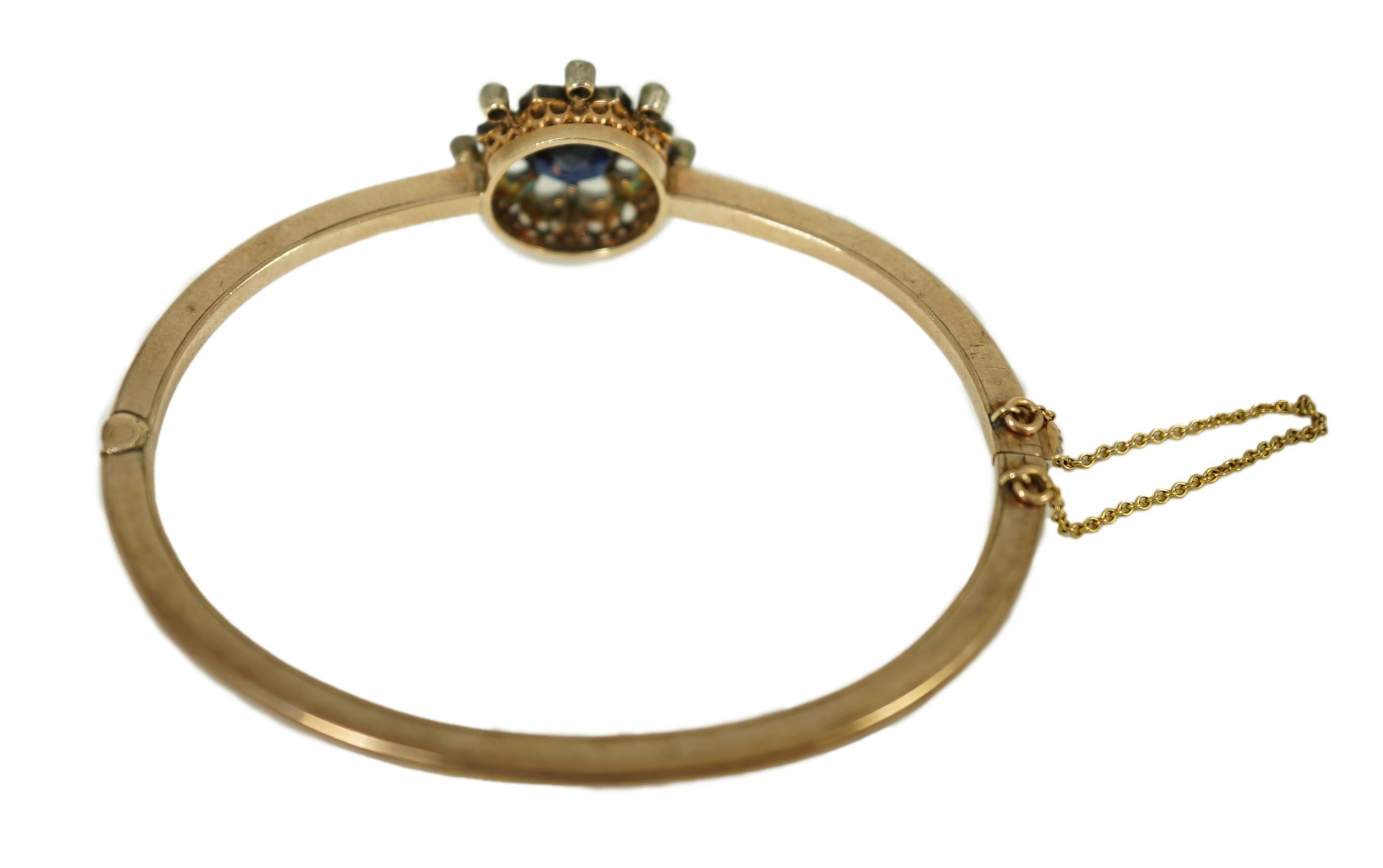 A Victorian gold, sapphire and diamond cluster set hinged bangle
